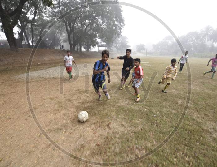 Children Playing Football  in A Ground on A Foggy Morning in Winter In  Guwahati, Assam