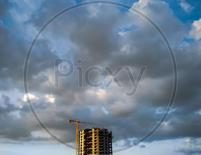 View of High Rise Building Construction with Clouds in Sky Background
