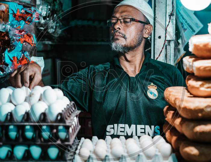 Shop keeper arranging Eggs in a Tray