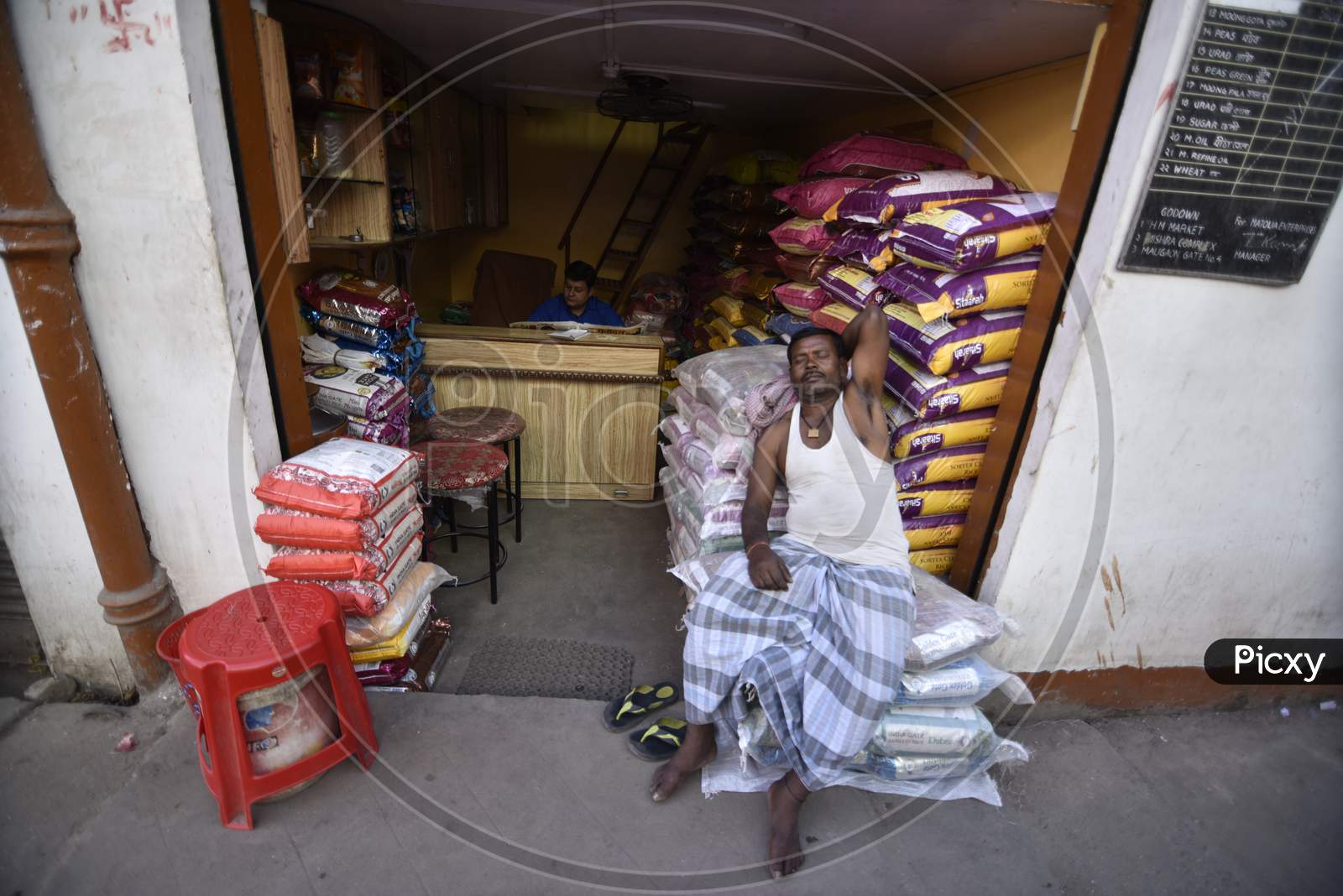 Daily Labor Worker  Taking Rest on Goods Bags At Vendor Shops In Guwahati Fancy Bazaar