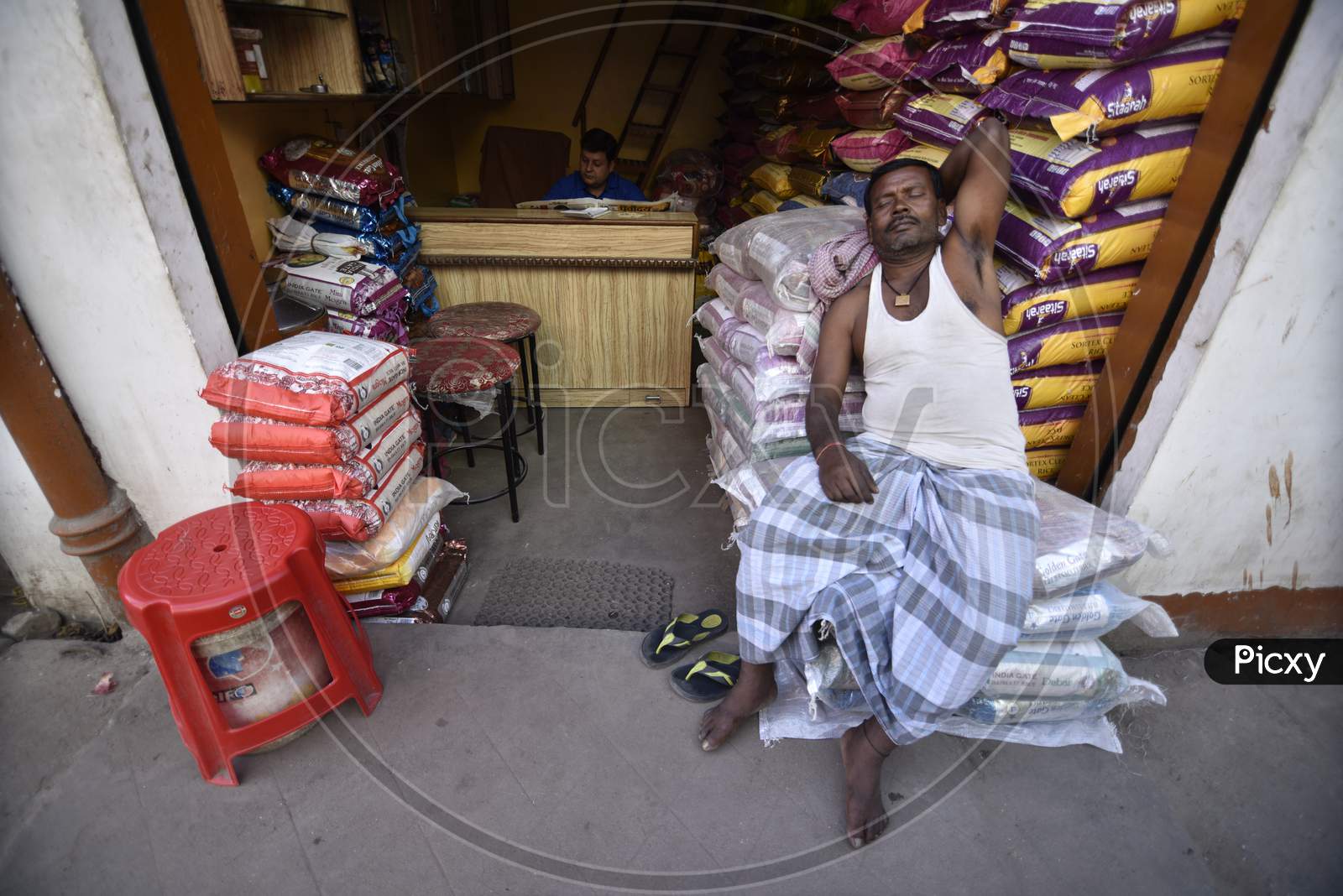 Daily Labor Worker  Taking Rest on Goods Bags At Vendor Shops In Guwahati Fancy Bazaar