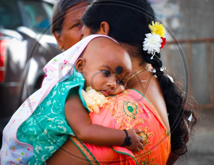 A Mother Carrying her baby on Shoulder