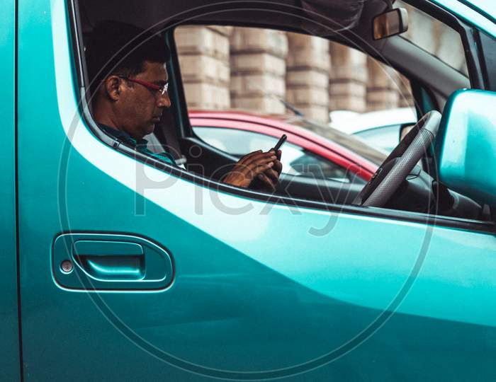 A Man using Mobile in Car