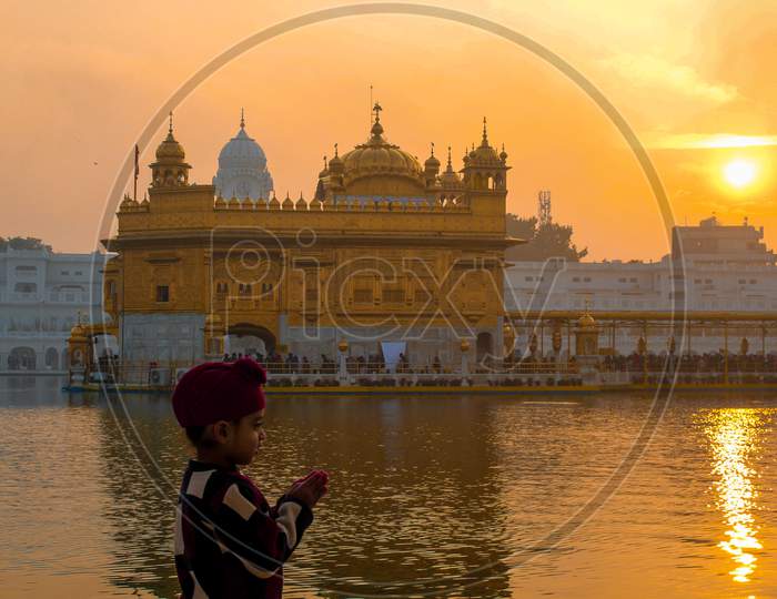 A Sikh Boy Offering Prayers At Amritsar Golden Temple