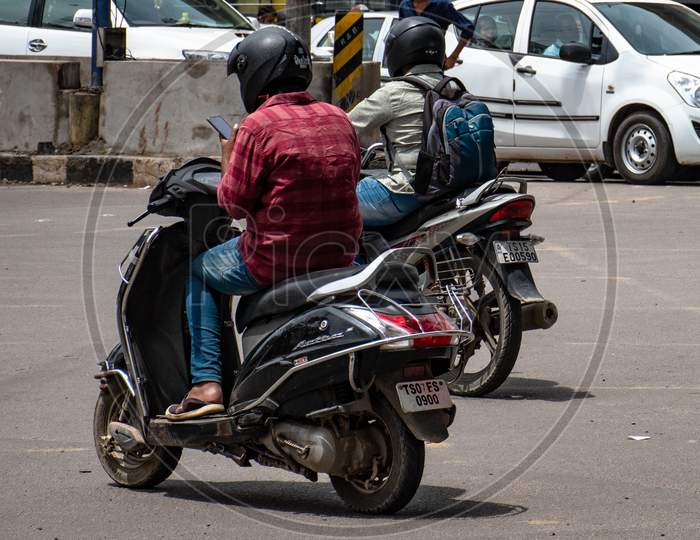 Man Using Mobile Phone While Driving Scooty