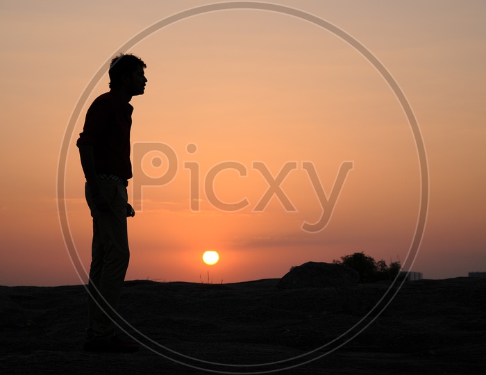 Silhouette Of Man Over Sunset Sun in Background