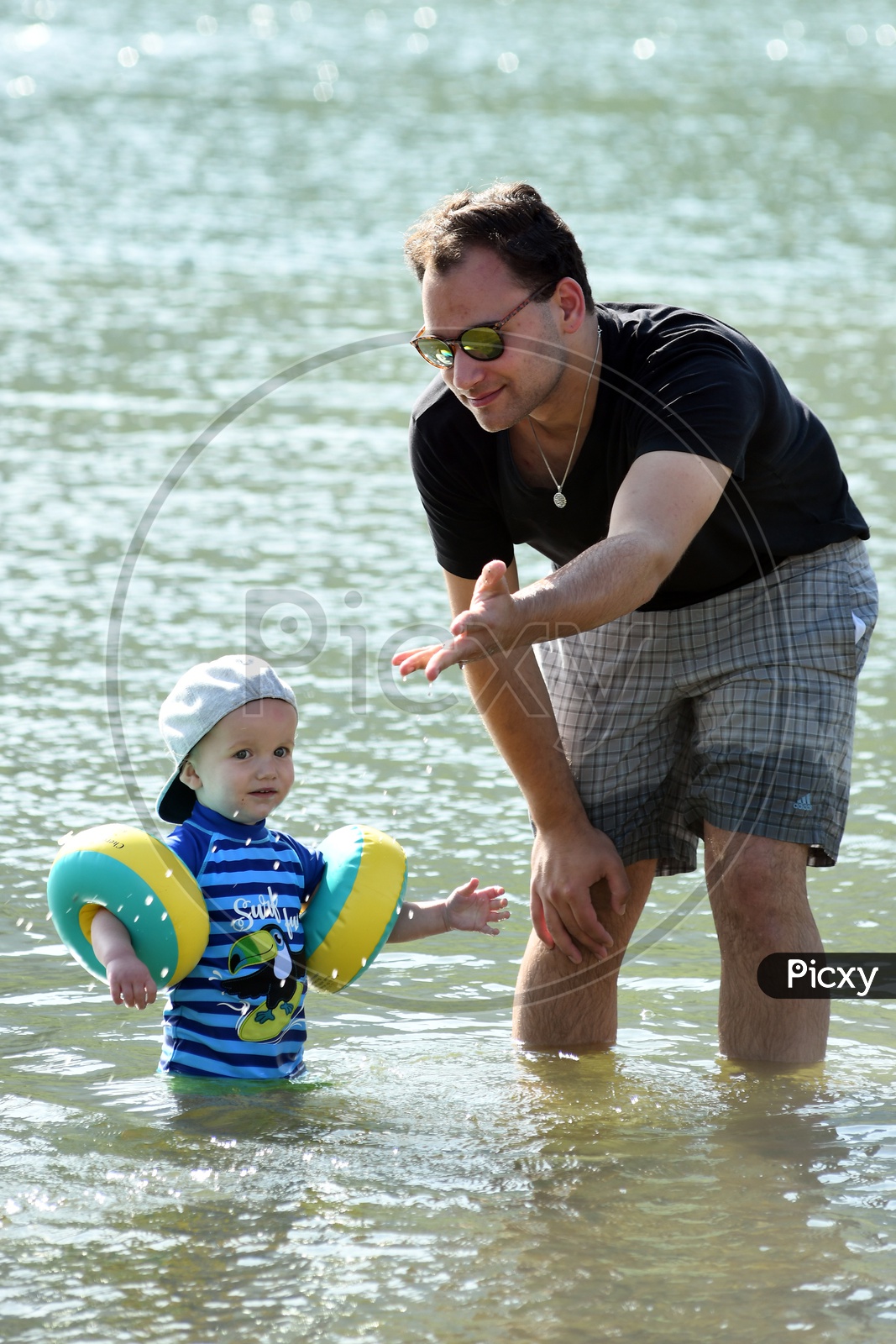 Father With His Son In a Lake Training him in Swimming