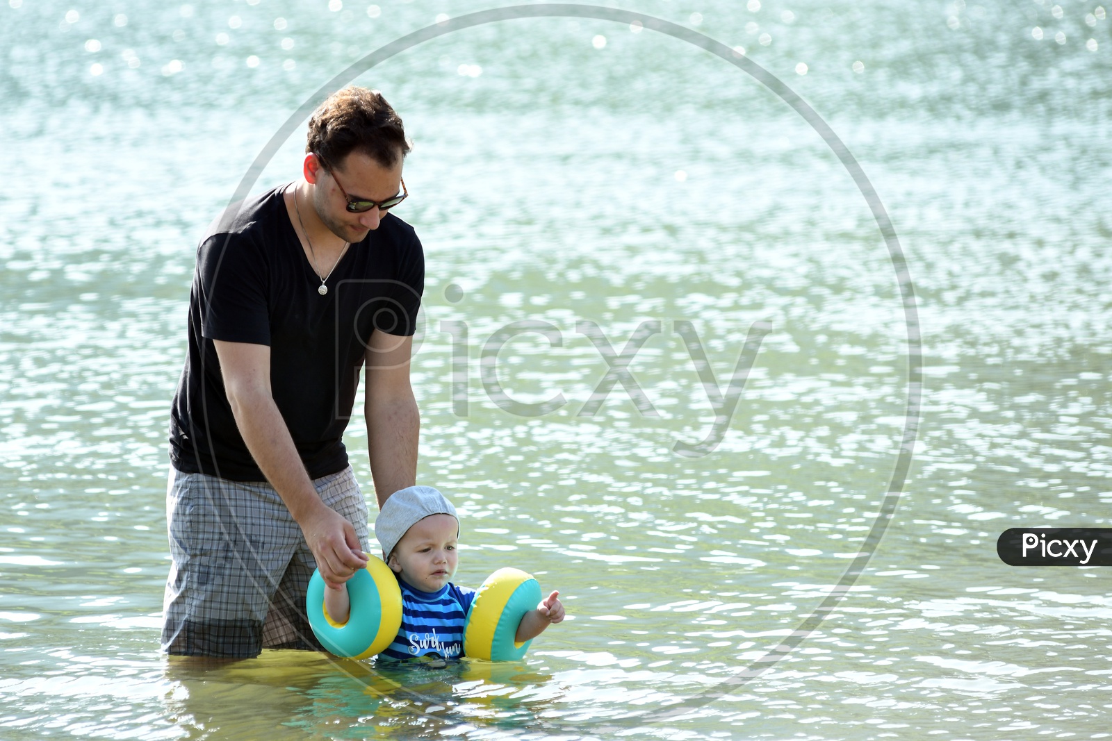 Father With His Son In a Lake Training him in Swimming