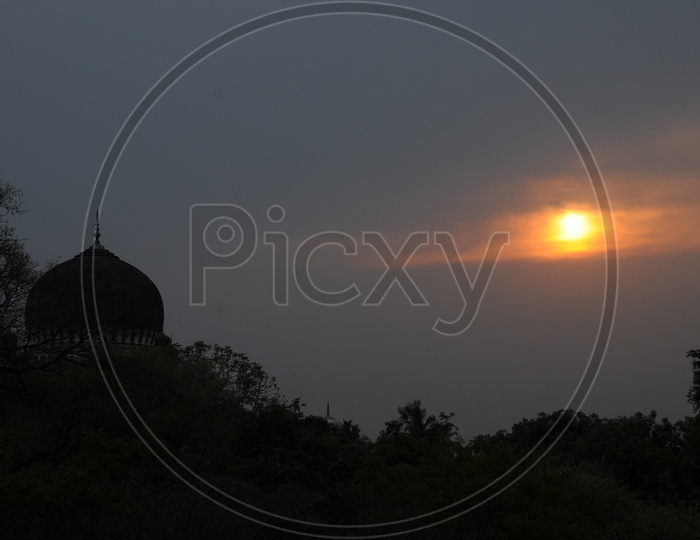 Silhouette Of Qutub Shahi Tombs With a Sunset Sun In Background