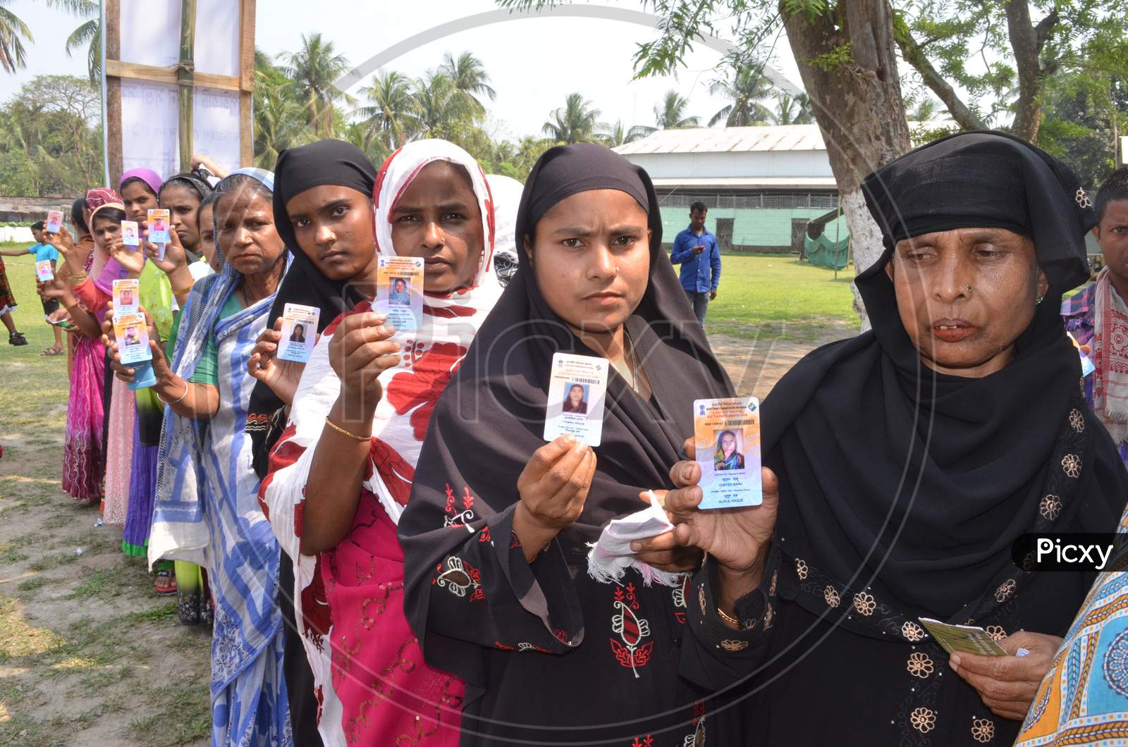 Muslim Woman Showing Voter ID Cards by Standing In Queue Lines For Casting Vote in Assam Assembly Elections 2016