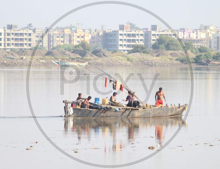 Boat Man Carrying Sand in Boats Ob a River Channel