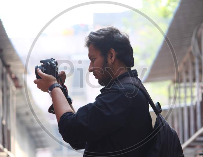 A Photographer Shooting With DSLR Camera