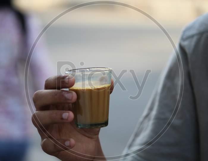 A Man Holding Tea Glass