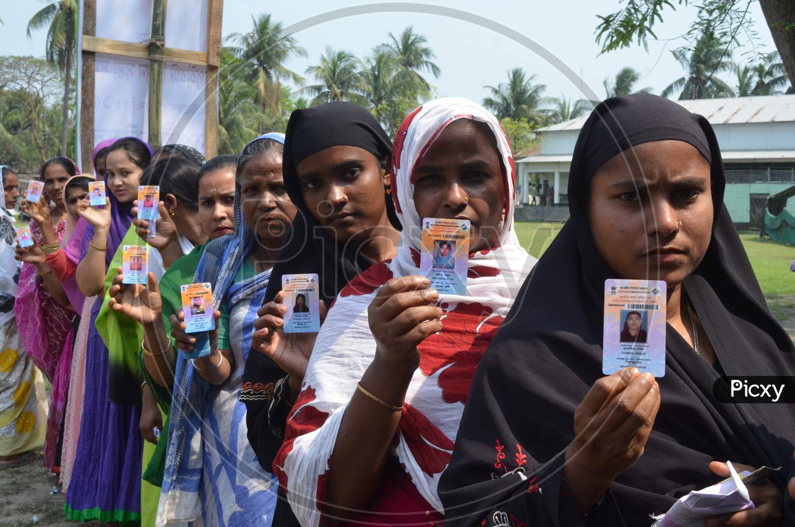 Muslim Woman Showing Voter ID Cards by Standing In Queue Lines For Casting Vote in Assam Assembly Elections 2016