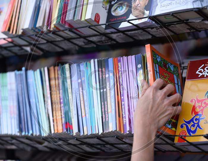 a woman picks a Bapu Ramaneeyam Book