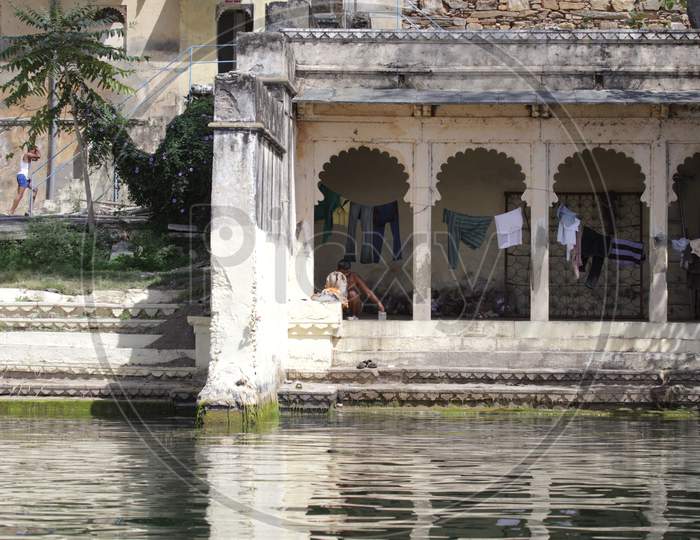 Indian Man taking shower by the pond