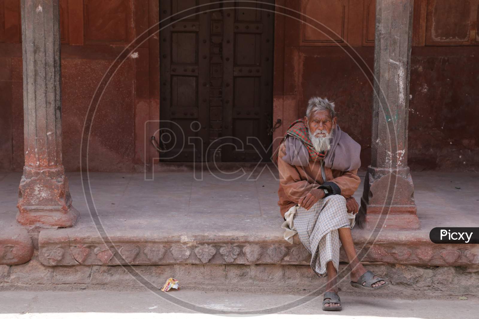 Old Man Sat outside a House