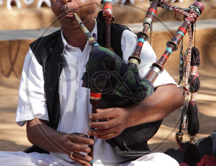 A Man blowing Uilleann pipes