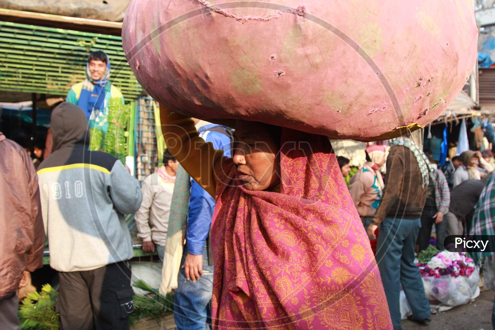 Indian Woman carrying a pile of clothes on her head