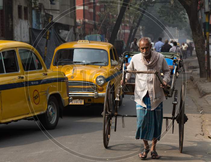 Indian Old Man Pulling a Rickshaw on the Kolkata Streets