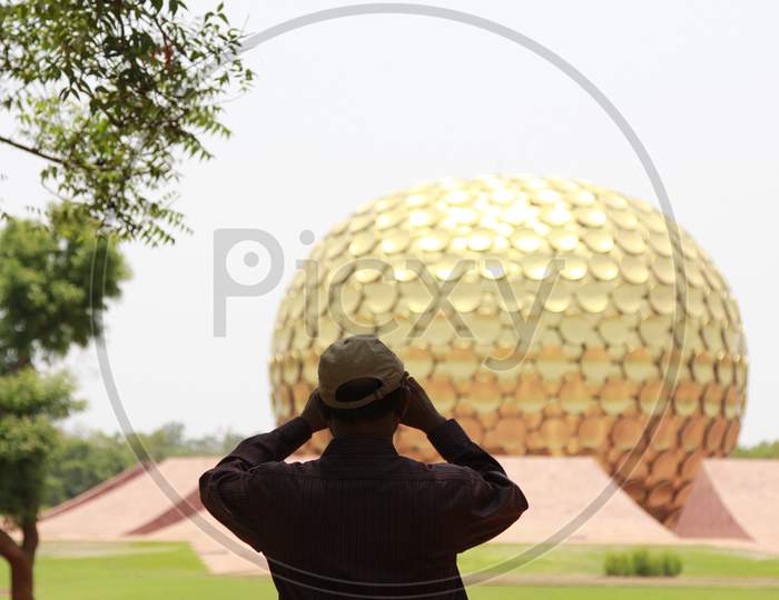 A Visitor Looking at Matrimandir, Auroville