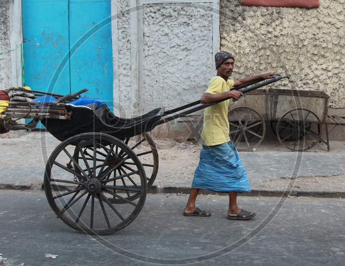 Indian Man Pulling Rickshaw on the Streets of Kolkata