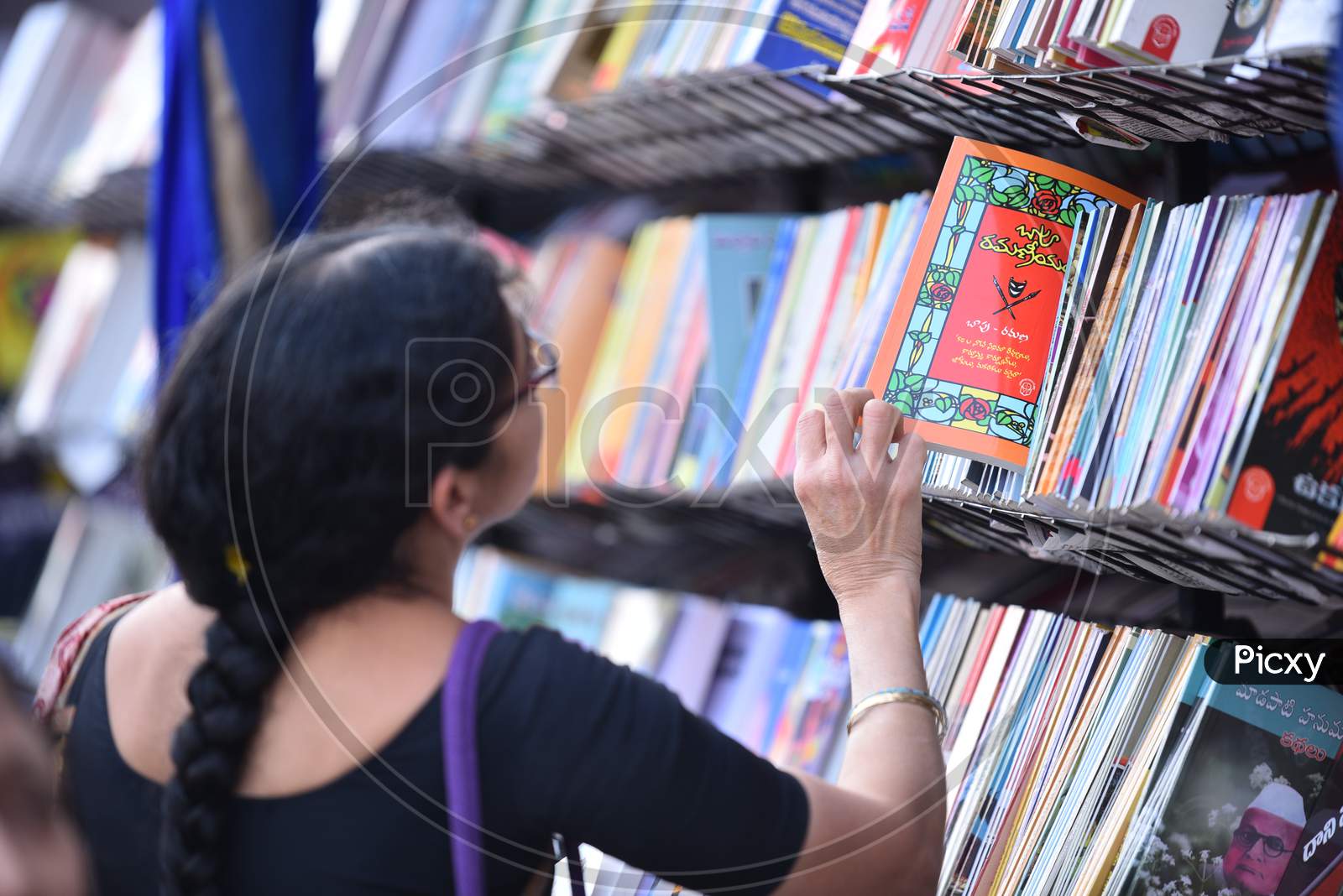 A woman picks up a Bapu Ramaneeyam Novel