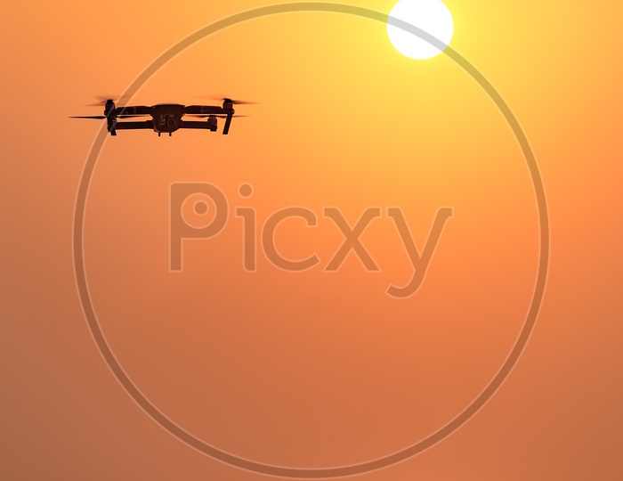 Closeup Shot of a Drone Flying with Sun in Background