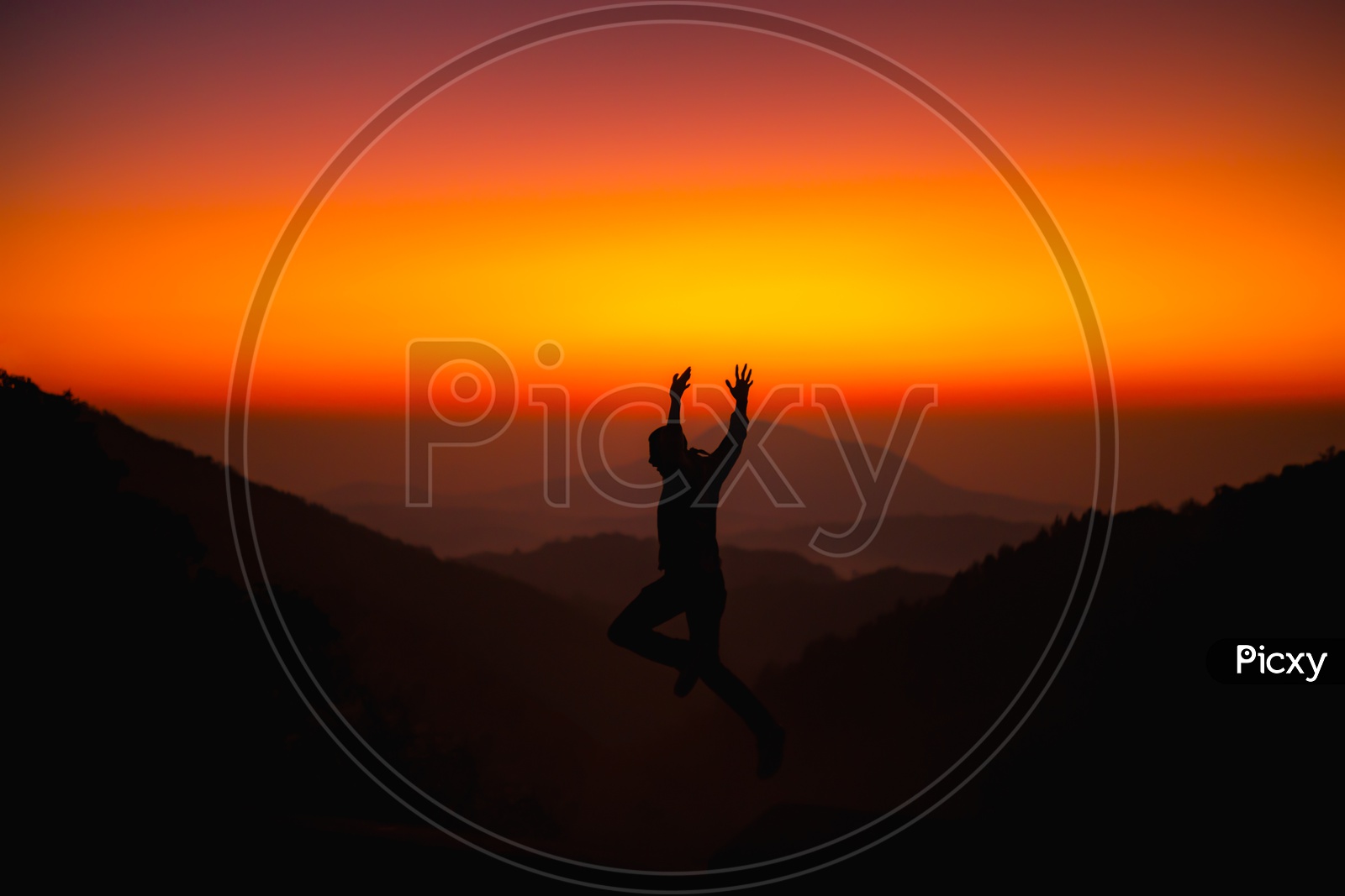 Silhouette Of Man Jumping In Joy Over Sunset Sky Background