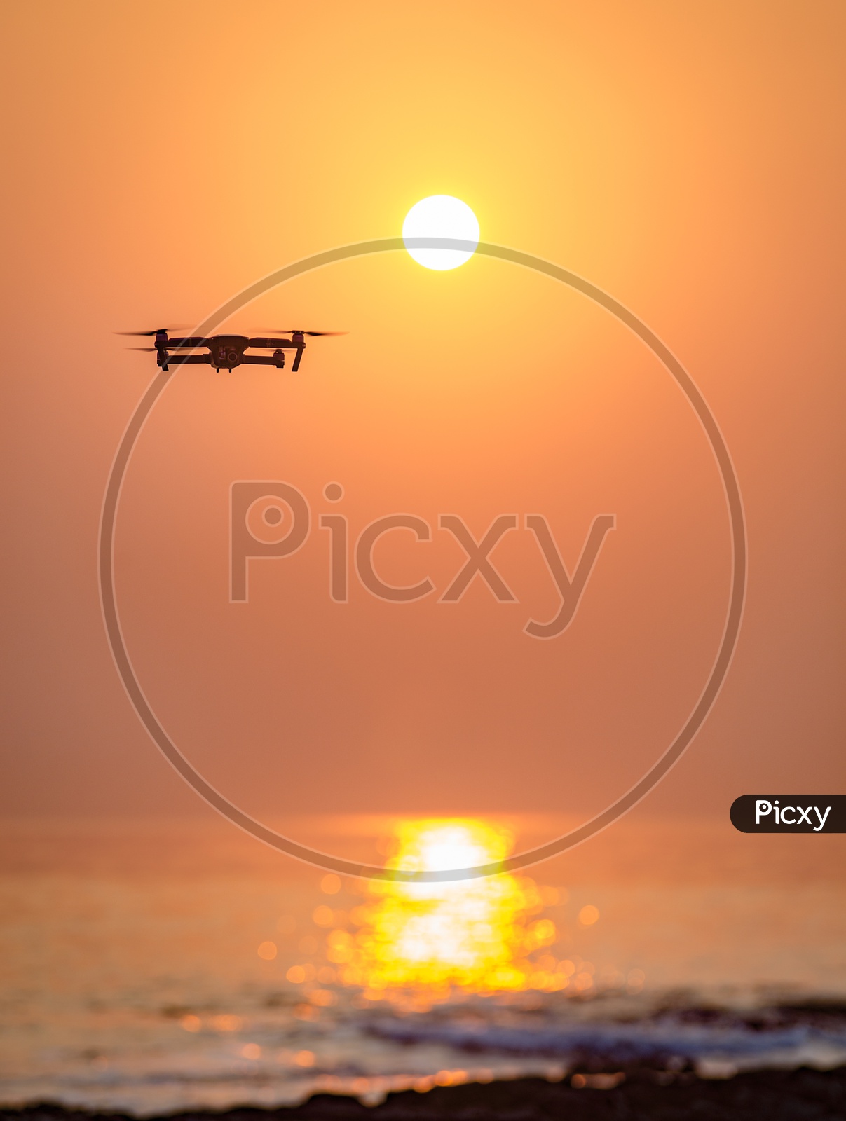 Closeup Shot of a Drone Flying with Sun in Background