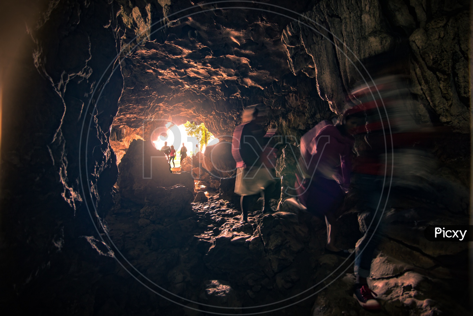 People Walking Into a Cave