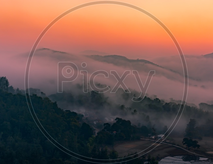 Landscape With Fog Clouds Over Valleys of Mountains And with Sunset Sky in Background