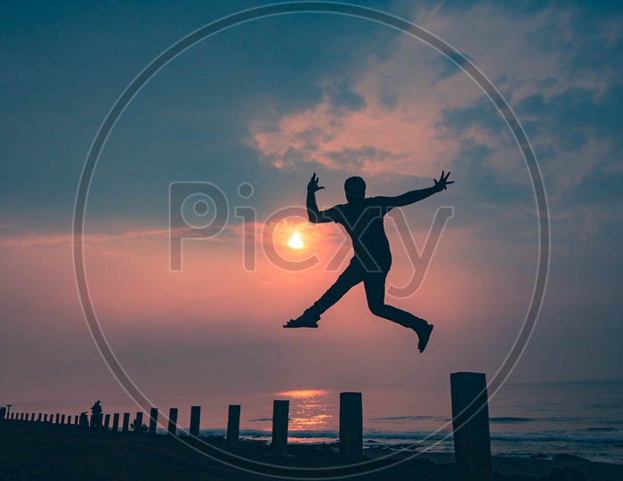Silhouette Of Man Jumping In Joy   In  At a Beach