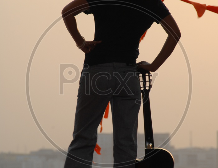 Silhouette of Woman Enjoying Sunset With A City