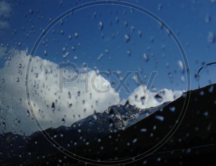 Landscape of Swiss Alps against water droplets on the car window