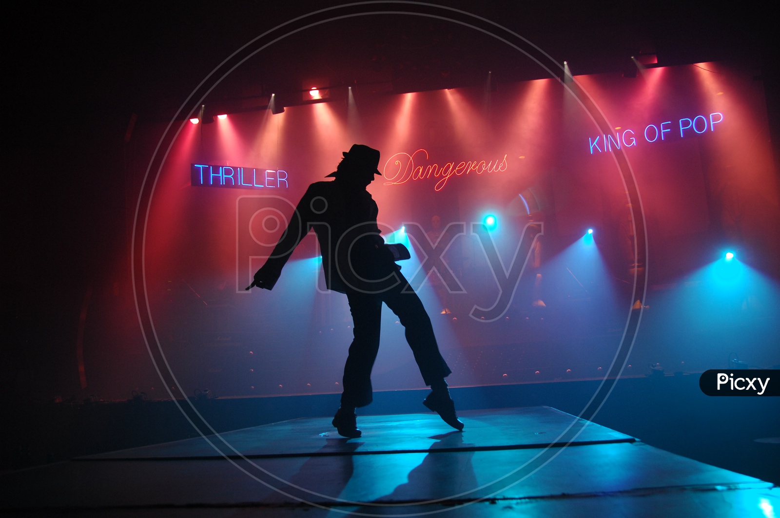 Silhouette Of a Dancer Making Micheal Jackson Postures on Stage With Neon Lights Background