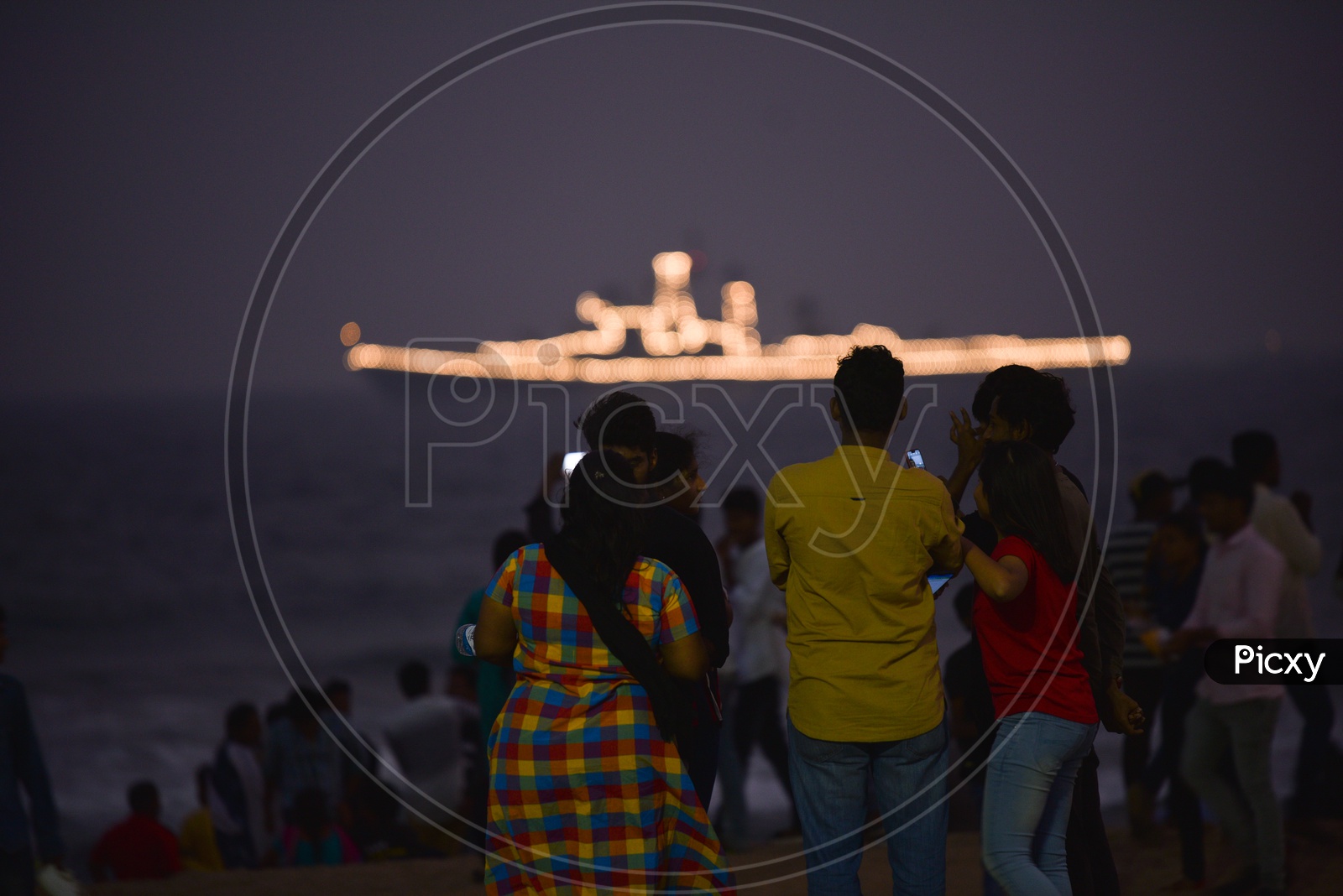 People watch a decorated Navy Ship on Navy Day,December 2019 in Visakhapatnam
