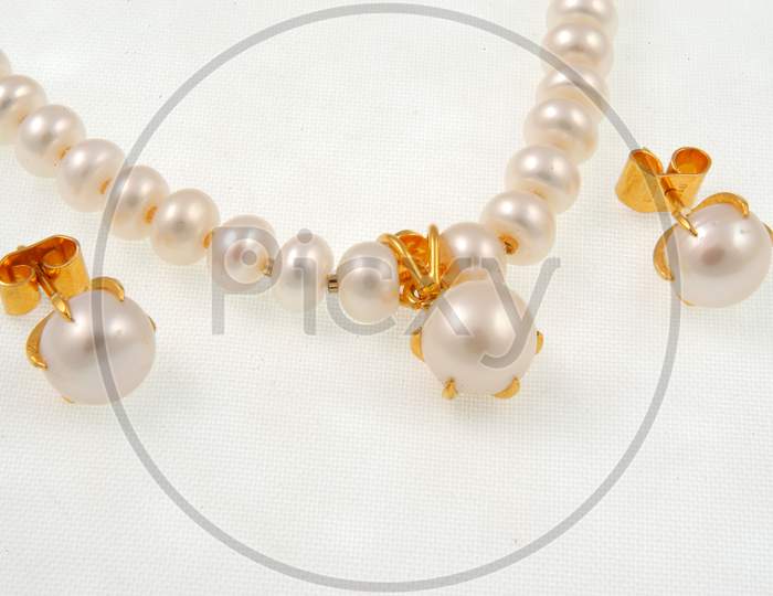 Diamond Necklace Jewelery  With White Pearls And Ear Rings  Over an Isolated White Background