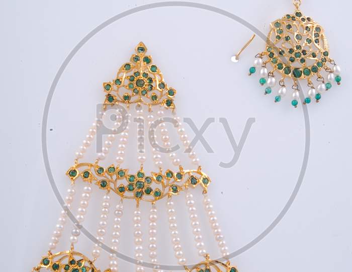 Gold Necklace With Gemstones And Ear Rings on an Isolated White Background