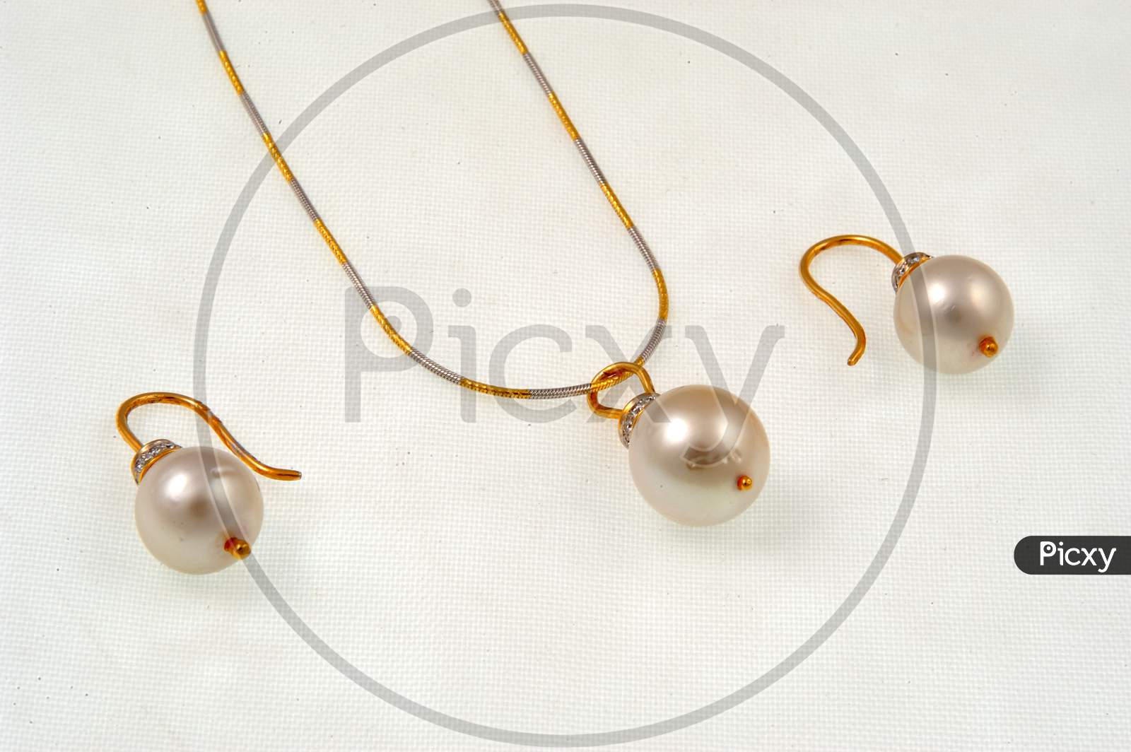 Gold Necklace and Ear rings With Pearls over an Isolated White Background