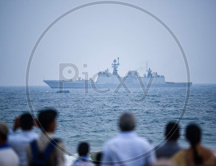 People watch an Indian Navy Ship at Visakhapatnam