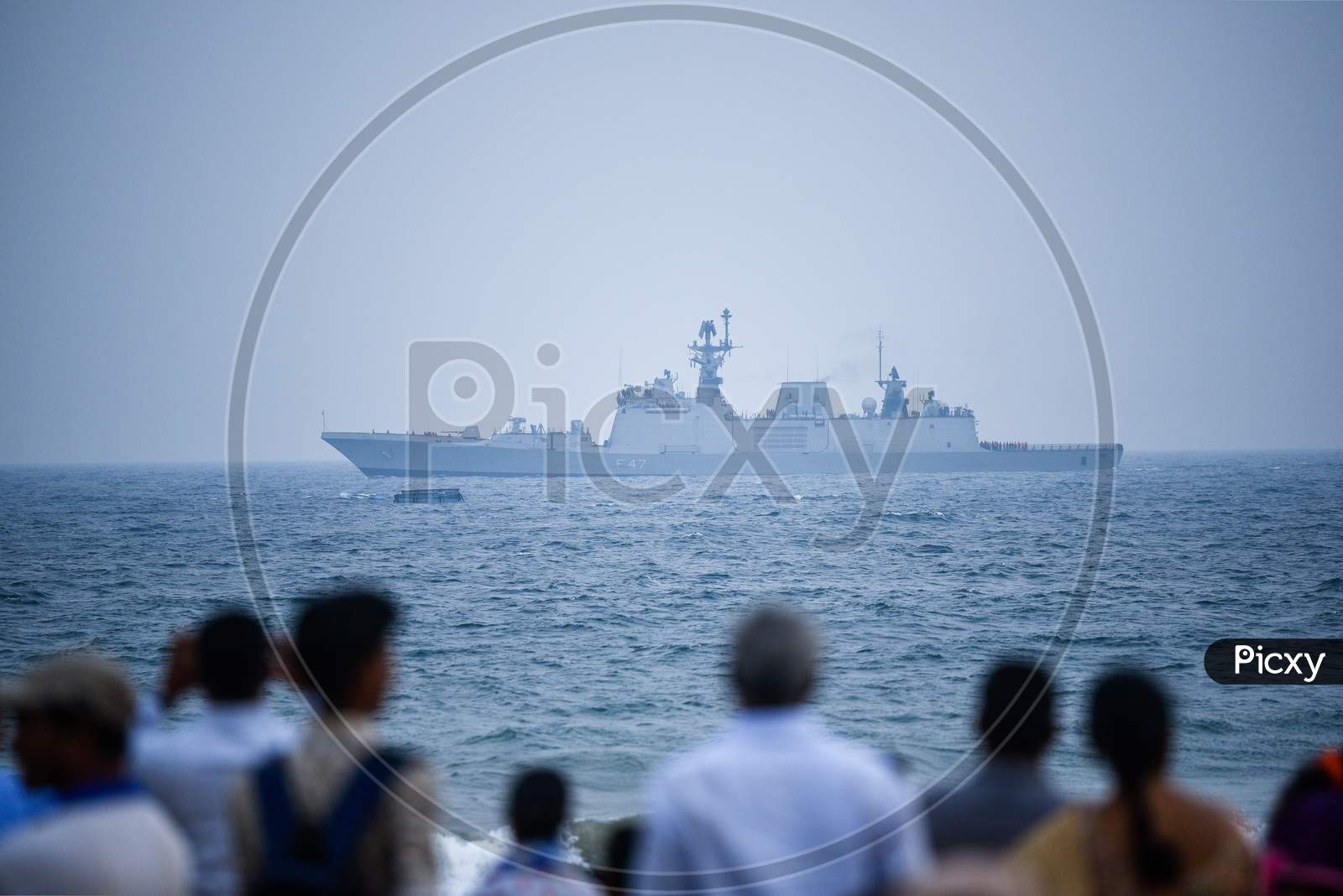 People watch an Indian Navy Ship at Visakhapatnam
