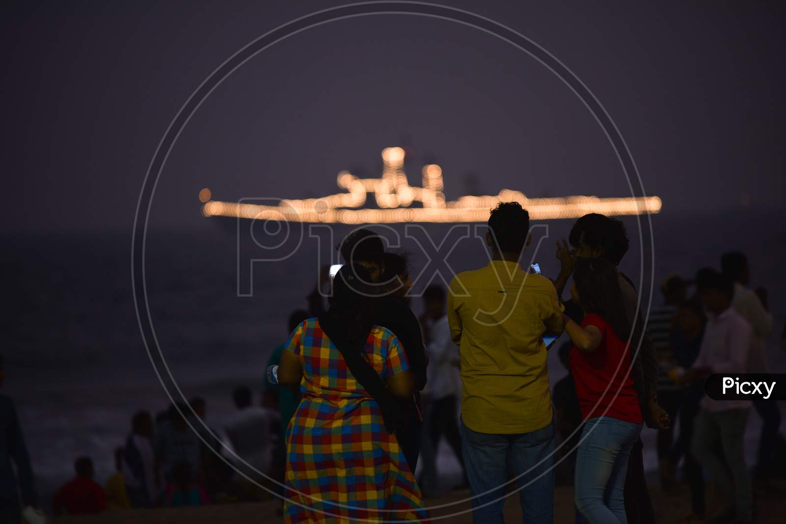 People watch an Indian Navy Ship in Visakhapatnam