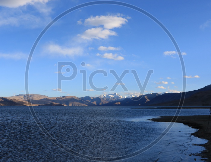 A  View Of River Valley In Leh With Snow Capped Mountains and blue Sky