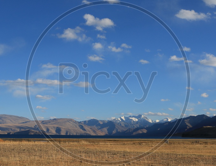 A River Valley With Sand Dunes ,Snow Capped Mountains and Blue Sky in Leh