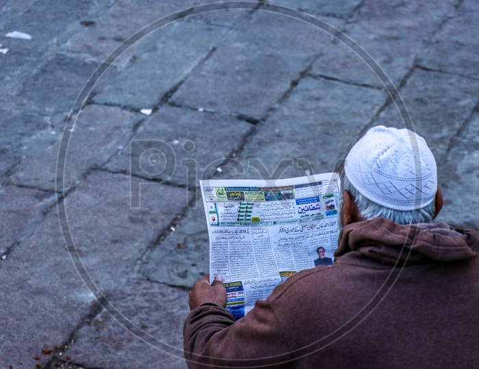 A Muslim Old Man Reading Urdu Newspaper