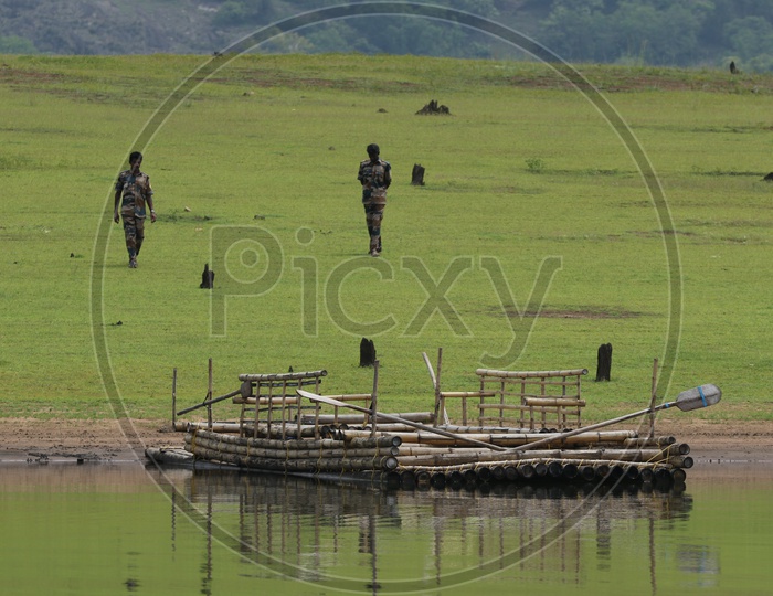 Military men and a raft in the river at Parambikulam Tiger reserve