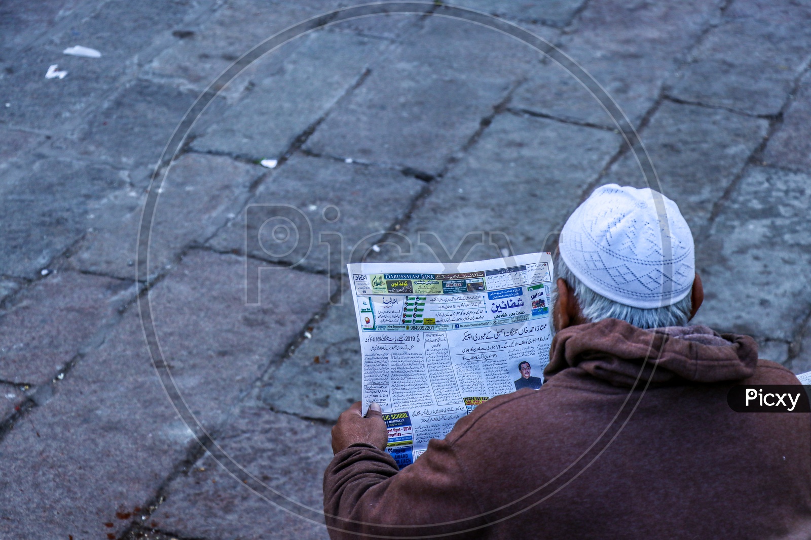 A Muslim Old Man Reading Urdu Newspaper