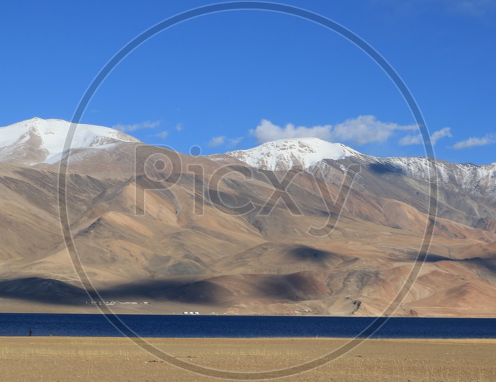 A River Valley With Sand Dunes ,Snow Capped Mountains and Blue Sky in Leh