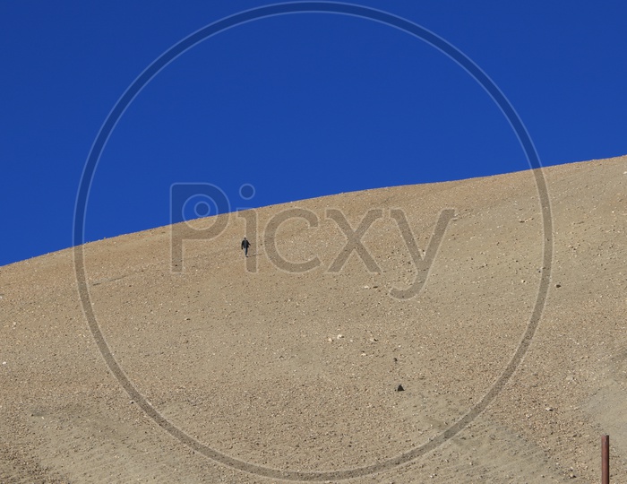 A Man Climbing The Sand Dunes in Leh